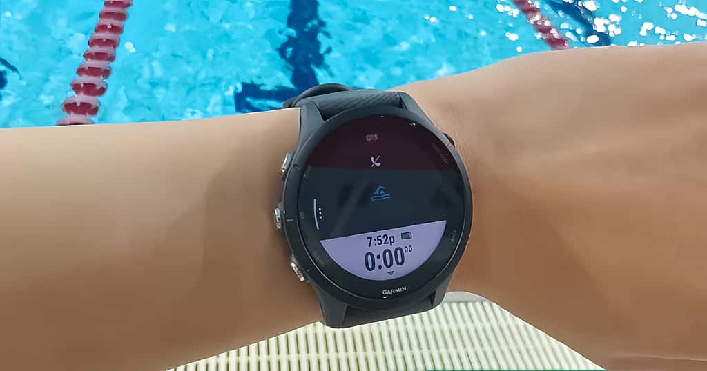 El reloj Garmin Swim 2 que lleva el nadador en la muñeca muestra la interfaz de entrenamiento de natación y el estado del GPS