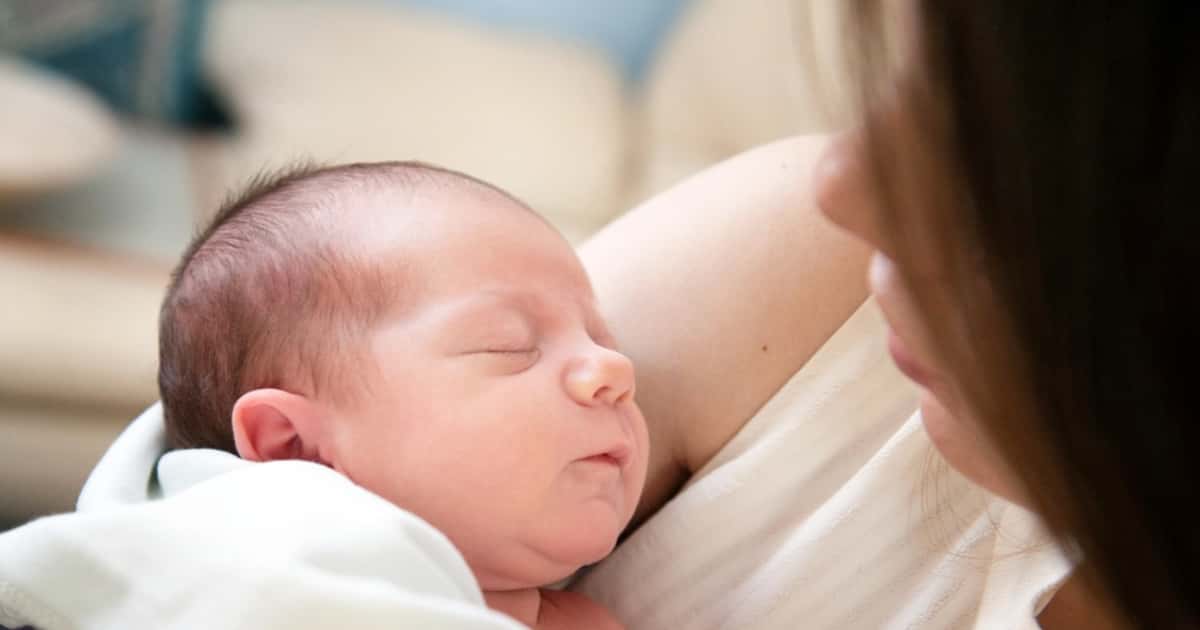 Mutter hält ihr Baby ruhig im Arm und schenkt ihm Aufmerksamkeit