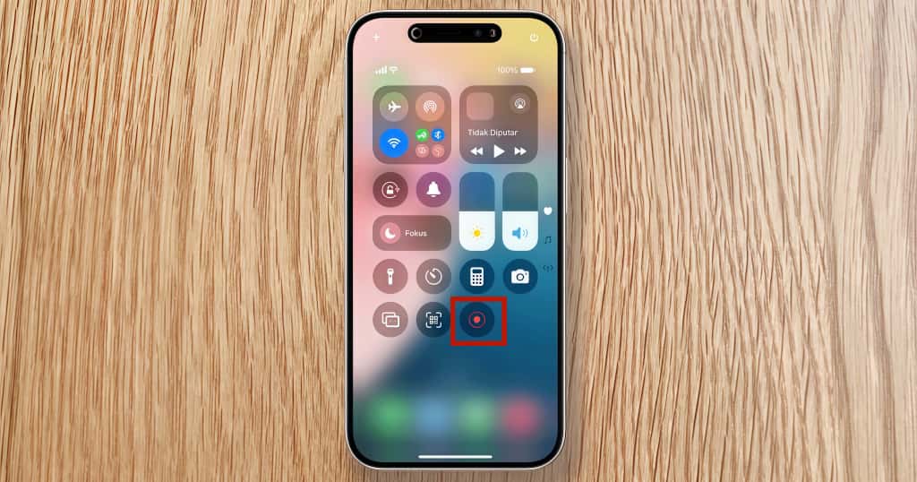 Antarmuka Pusat Kontrol iPhone menampilkan ikon perekaman layar yang disorot merah, menunjukkan cara mudah memulai perekaman layar di iPhone Anda
