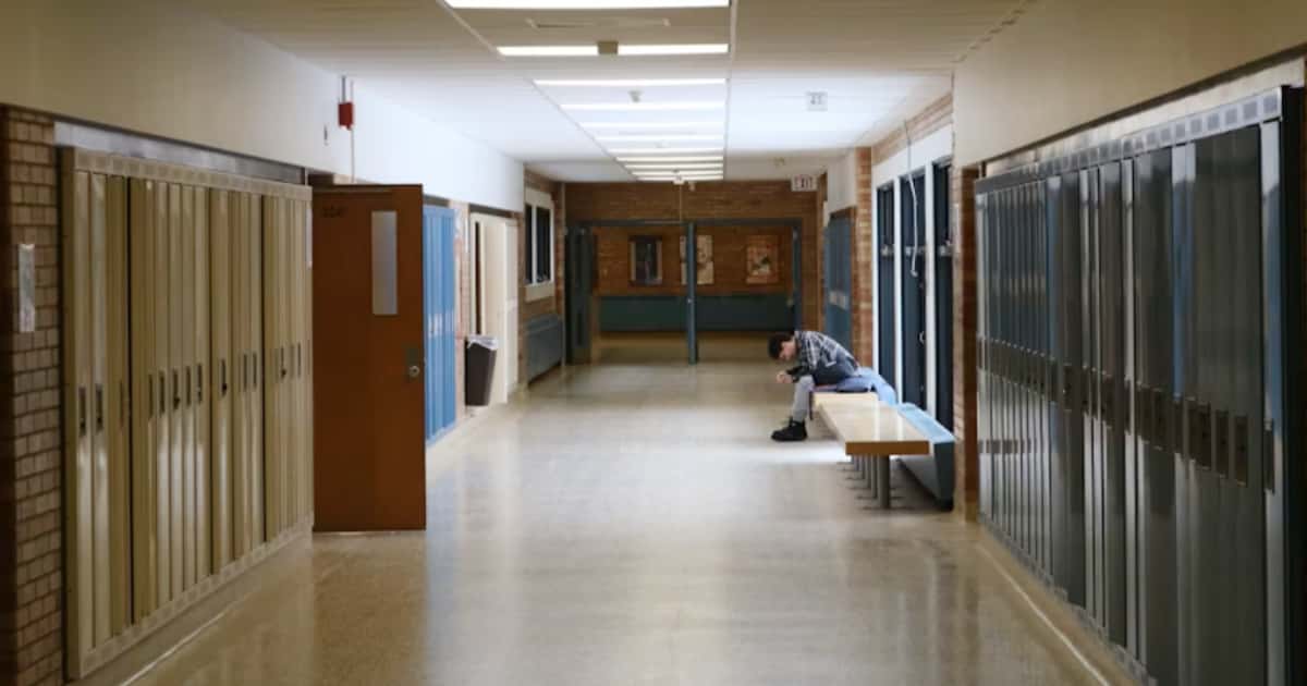 Kind sitzt allein im Schulflur und wirkt nachdenklich