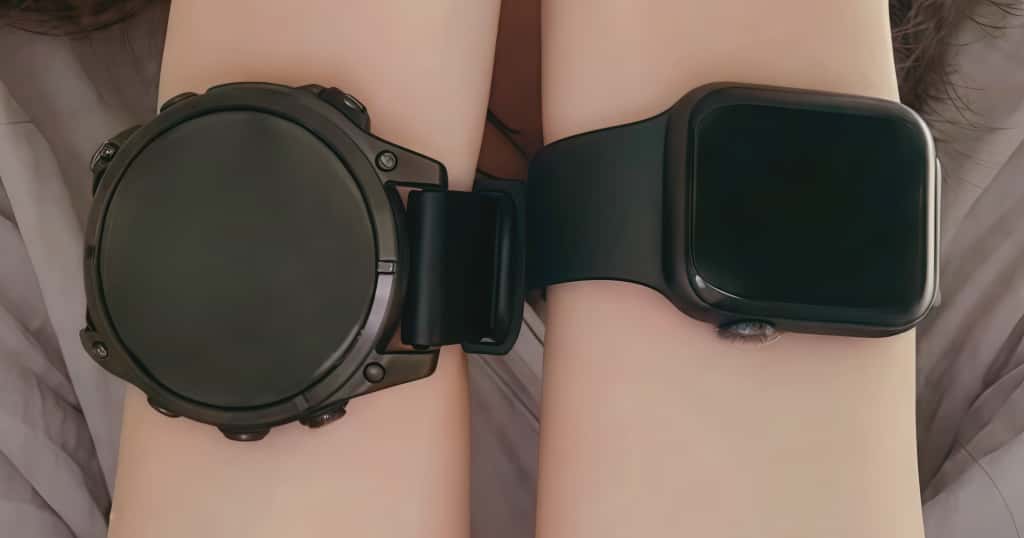 Garmin dan Apple Watch dikenakan di masing-masing tangan untuk membandingkan cara memilih jam tangan yang tepat