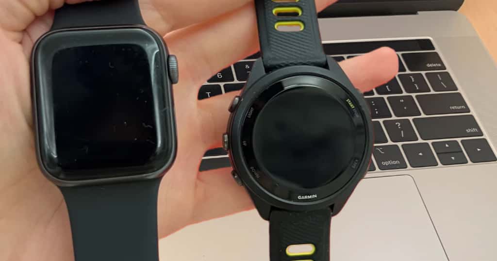 Apple WatchとGarminスマートウォッチを手に持って比較している写真