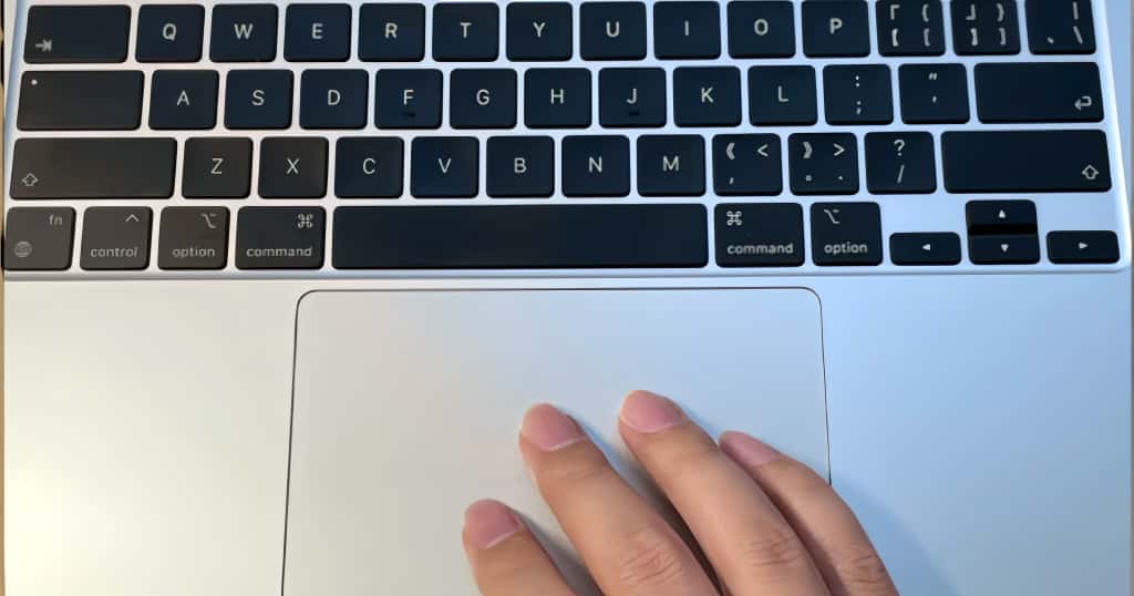 Con una mano apoyada en el trackpad de la MacBook, las teclas Opción (Alt) a ambos lados del teclado son claramente visibles. Cómo identificar y usar la tecla Alt al cambiar de Windows a Mac