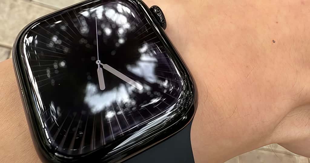 Versi aluminium hitam dari Apple Watch dikenakan di pergelangan tangan untuk menggambarkan bahan aluminium dan proses pembuatan Apple Watch