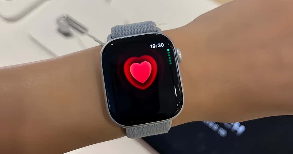 Apple Watch menampilkan ikon hati merah di layar saat digunakan di pergelangan tangan, menunjukkan kondisi terbaik untuk pengukuran detak jantung yang akurat.