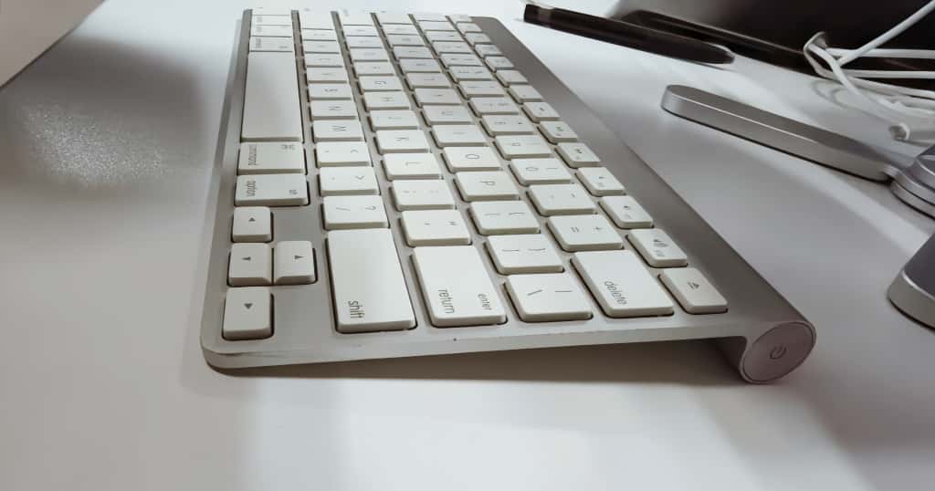 Un teclado inalámbrico, fotografiado de lado, está sobre un escritorio, mostrando cómo sacar el máximo partido a un teclado Mac